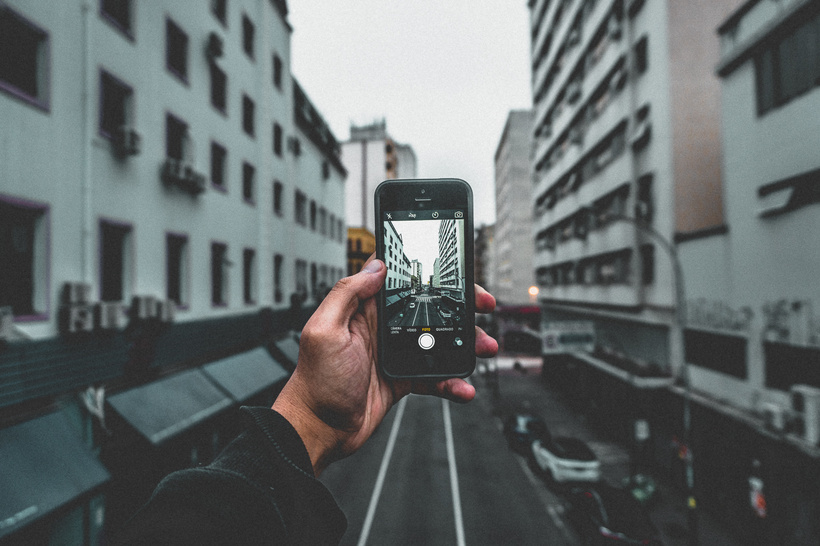 Man Holding Smartphone Capturing Roadway